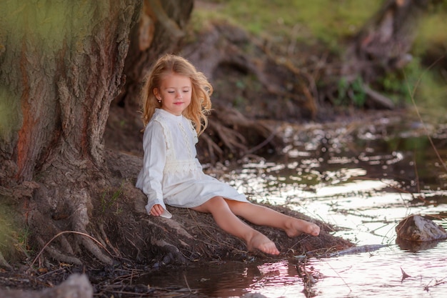 Photo beautiful blonde girl near the pond, in nature