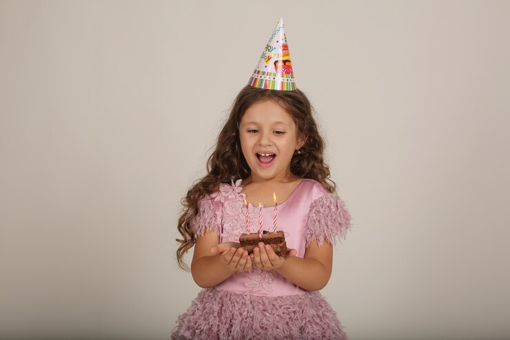 그녀의 손 생일에 케이크 한 조각과 핑크 드레스에 아름 다운 금발 소녀