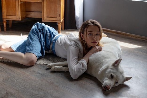 Beautiful blonde girl playing with white husky dog