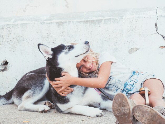 Beautiful blonde girl poses with pet Siberian Husky