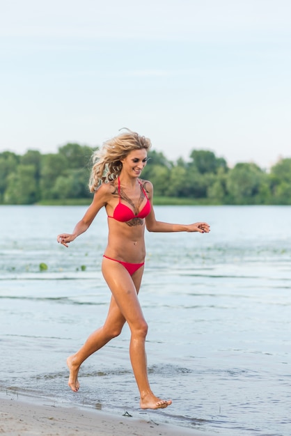 Beautiful blonde girl running on the beach