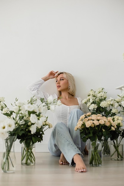 Beautiful blonde girl sitting in flowers