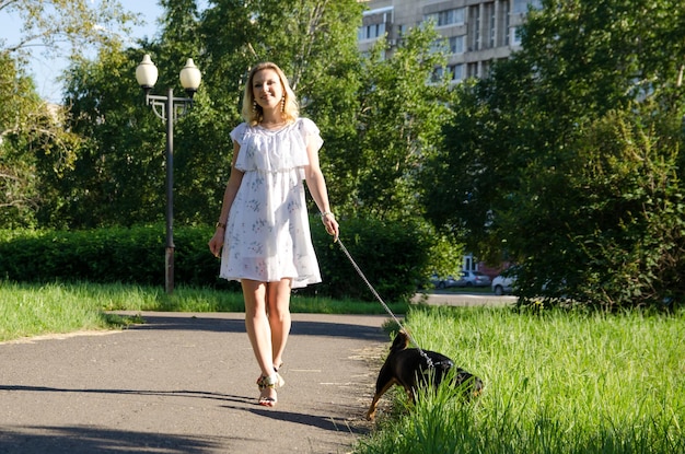 Фото Красивая блондинка с милой собакой на прогулке.