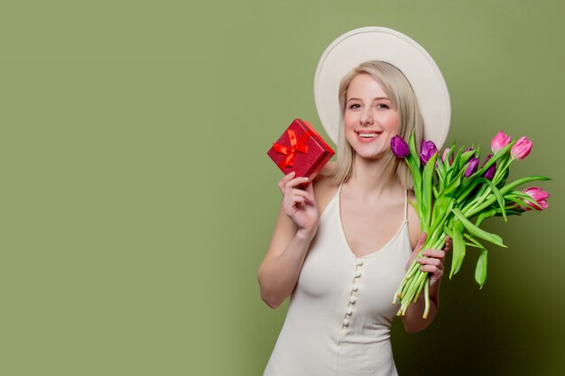 Beautiful blonde girl with tulips and gift box