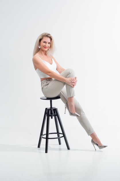 Beautiful blonde in jeans in the studio on a light background