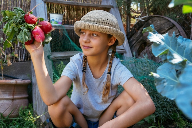 Beautiful blonde little girl harvesting organic