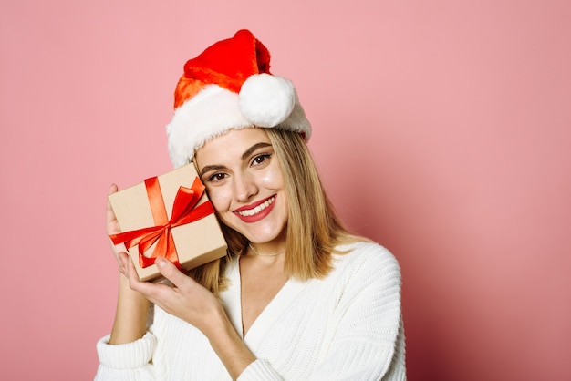 Beautiful blonde on a pink background in the studio Concept for Christmas shopping gift giving