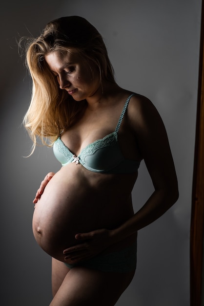 Beautiful blonde pregnant woman studio portrait
