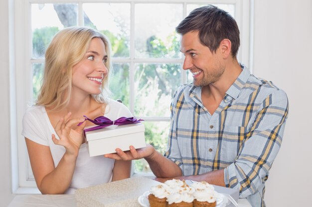 Photo beautiful blonde receiving a gift box