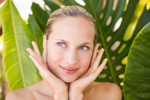  Beautiful blonde smiling at camera behind leaf