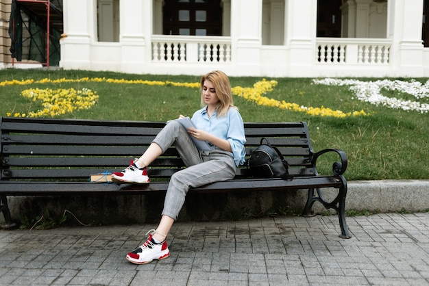Photo beautiful blonde student girl on a bench