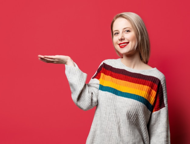 Beautiful blonde in sweater on red