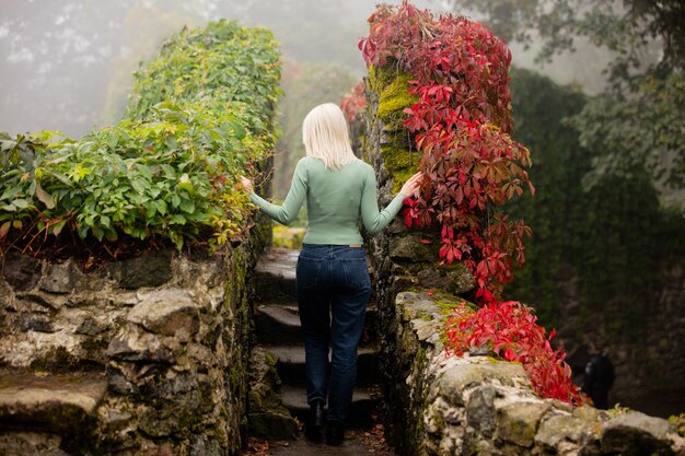 Beautiful blonde woman in a garden with Virginia creeper in autumn