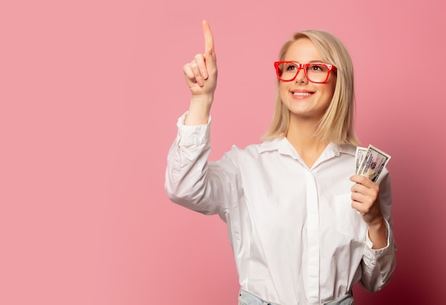 Beautiful blonde woman in glasses with dollars cash