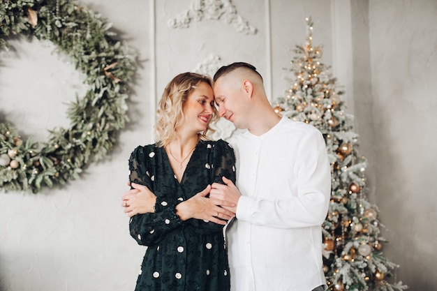 Bella donna bionda che mantiene il sorriso sul suo viso mentre guarda il suo partner durante la sessione fotografica