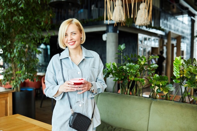 Beautiful blonde woman relaxing at the bar and drinking a cocktail Woman having fun