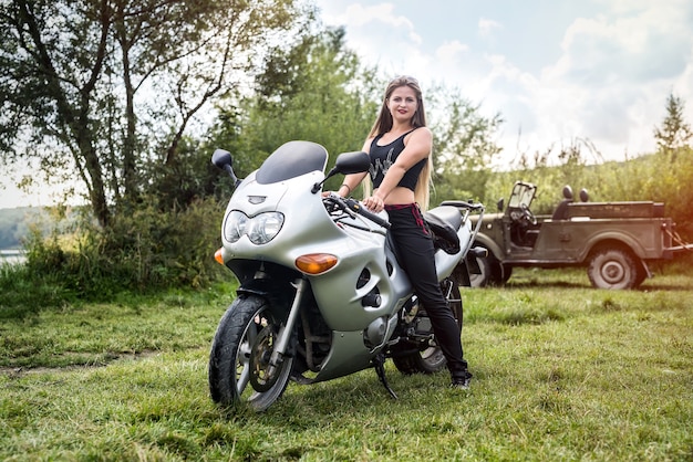 Una bella donna bionda seduta su una moto