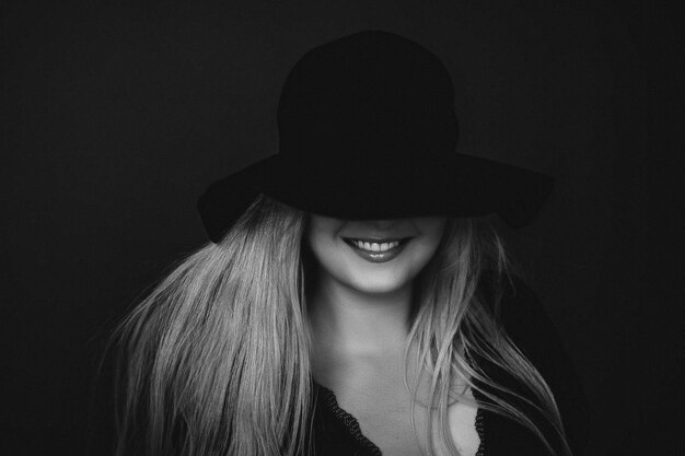 Beautiful blonde woman wearing a hat artistic film portrait in
black and white for fashion campaign and beauty brand