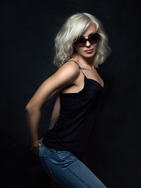 Beautiful blonde woman wearing sunglasses posing. Model tests. Fun fashion