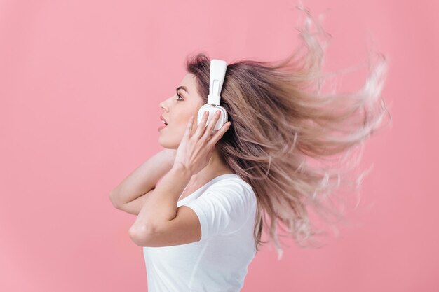 beautiful blonde woman in white headphones listens to music