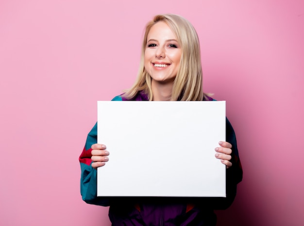 Beautiful blonde woman with banner on pink wall