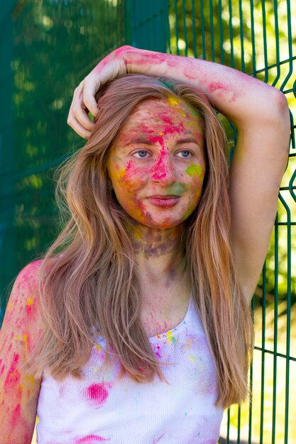 Beautiful blonde woman with colorful powder Holi on her face