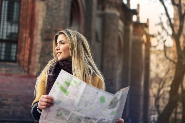 Photo beautiful blonde woman with a map