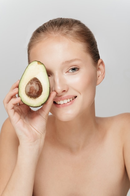 Beautiful blonde woman with perfect skin and an avocado