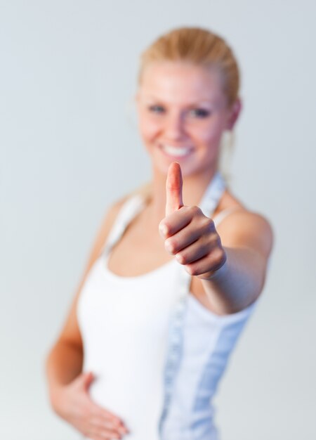 Beautiful blonde woman with thumb up after weight loss focus on thumb