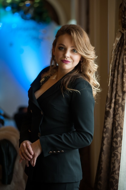 Beautiful blonde woman with wavy hair in a business black suit
