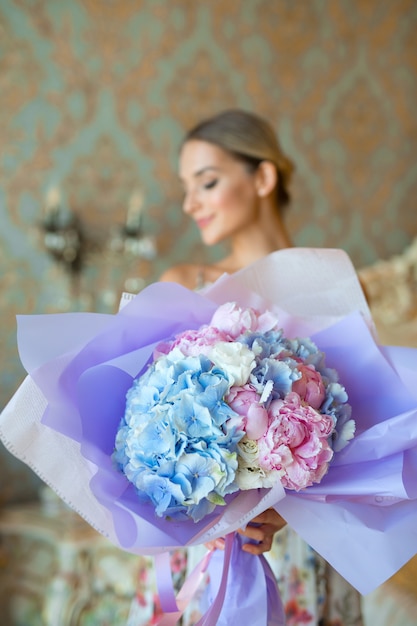 Photo beautiful blue bouquet in woman's hands