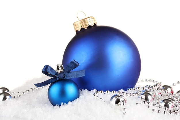 Beautiful blue Christmas balls on snow, isolated on white