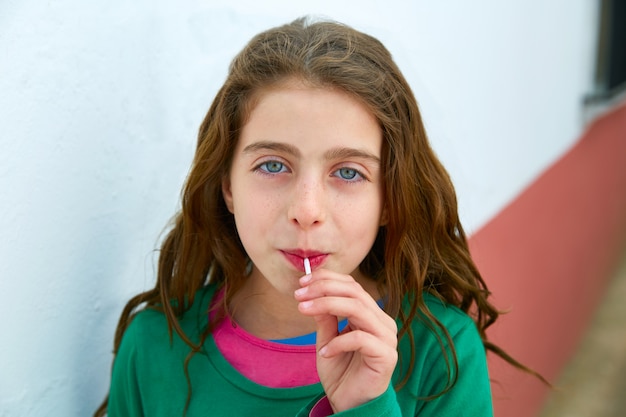 Beautiful blue eyes kid gils eating lollipop sweet