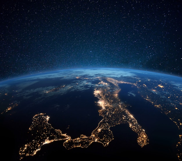 Фото Красивая голубая планета земля с огнями ночного города. центральная европа и италия ночью вид из космоса. современные города и электричество