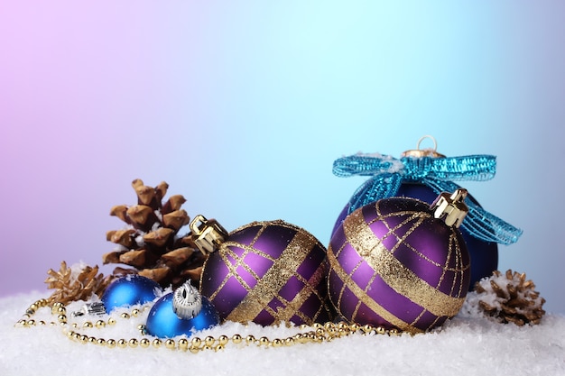 Beautiful blue and purple Christmas balls and cones on snow