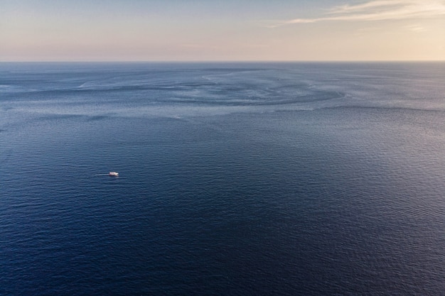 Красивый синий морской горизонт с вечерним небом и кораблем