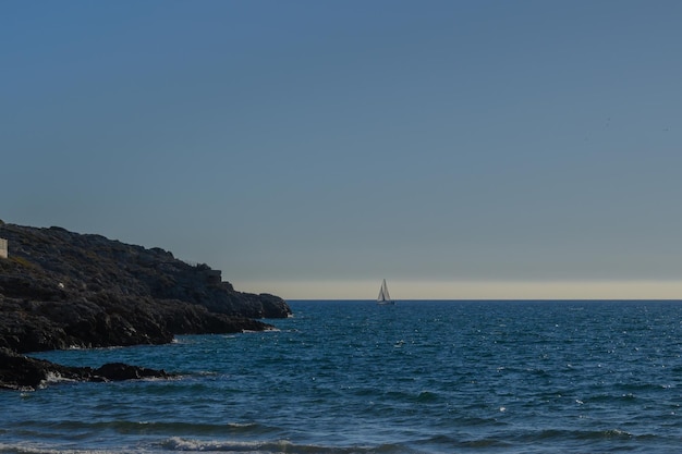 Beautiful blue sea with little boat and rocks