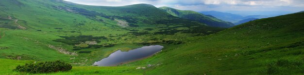 美しい青い空とカルパティア山脈の高い岩。 「Nesamovyte」湖のパノラマ