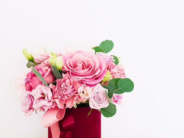 Beautiful bouquet of blooming flowers in red flower box on white background holiday gift luxury floral design