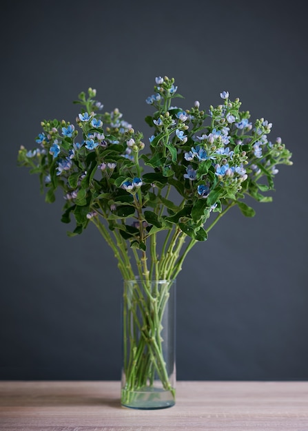 Beautiful bouquet of blue flowers in a transparent glass vase.