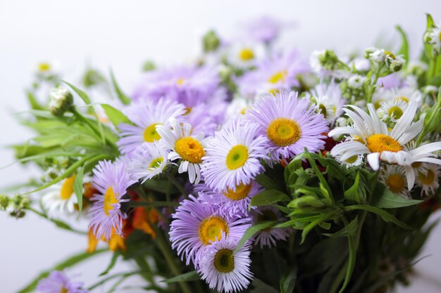 明るい背景のクローズ アップに明るい野の花春の色とりどりの花の美しい花束