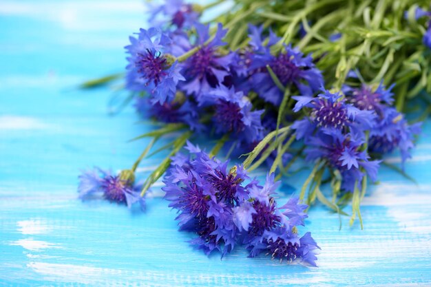 Beautiful bouquet of cornflowers on blue wooden background