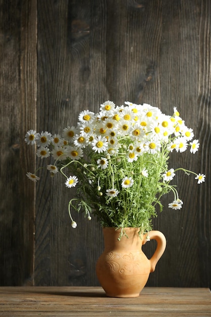 木製の背景の鉢に麗な花束の花束