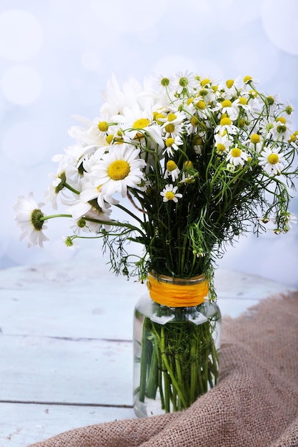 Beautiful bouquet of daisies on wooden background