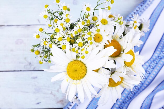 Beautiful bouquet of daisies on wooden background