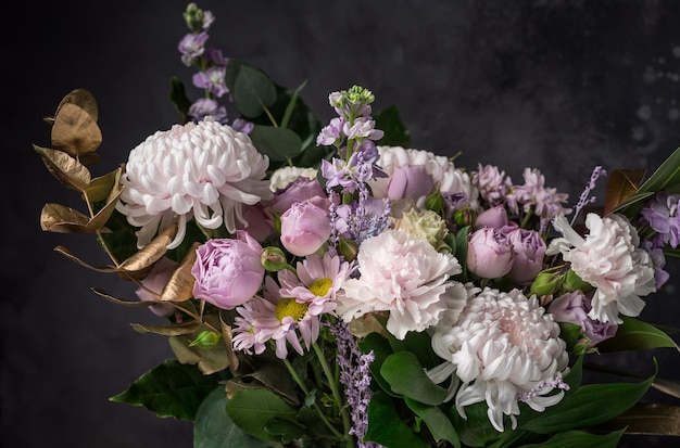 Bellissimo bouquet di fiori diversi e foglie decorative dorate