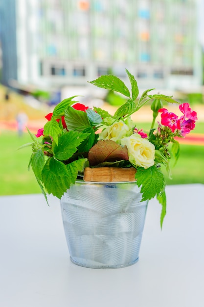 Beautiful bouquet of flowers in small metal bucket. Interior and garden decoration.