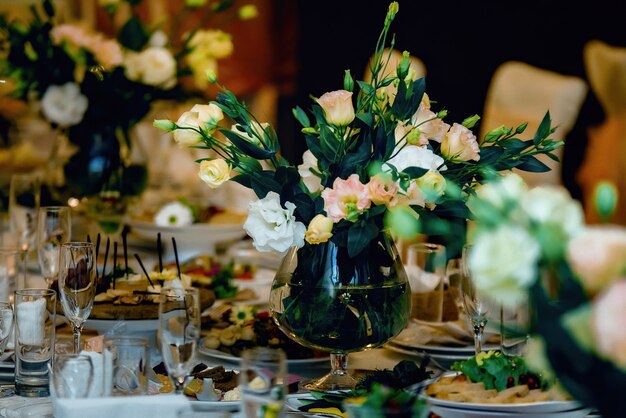 休日や結婚式のディナーのためのレストランの結婚式のテーブルで花の美しい花束