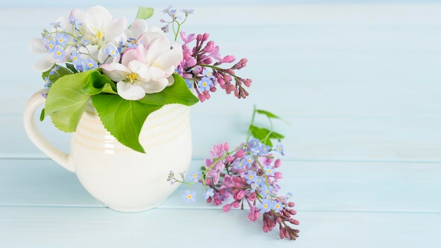 Beautiful bouquet in a jug on a blue background