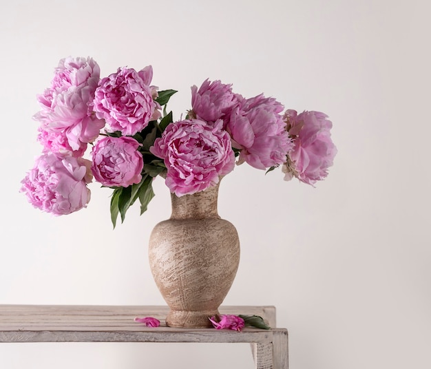 Beautiful bouquet of pink peonies in vase on a gray background